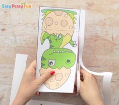 someone is holding up a paper cutout to make a dinosaur card with the words easy peasy fun on it