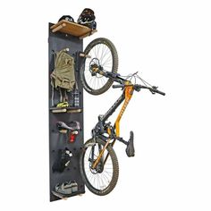 a bike hanging on the back of a bicycle rack with tools and gear attached to it