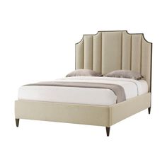 an upholstered bed with beige linens and headboard