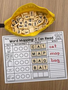 a yellow bag filled with letters and words next to a printable word map on a table