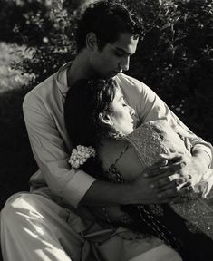 a man and woman embracing each other in black and white