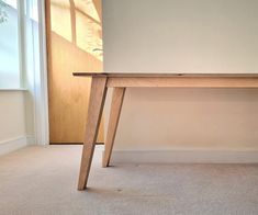 a wooden table sitting on top of a carpeted floor