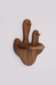 a wooden wall mounted shelf with two birds on it's sides and one bird hanging from the top