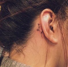 a woman with a small tattoo behind her ear