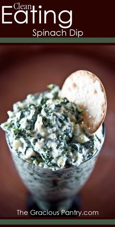 spinach dip with pita chips in a small glass bowl on a wooden table