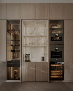 an empty kitchen with wooden cabinets and marble counter tops is seen in this image, the shelves are filled with wine glasses