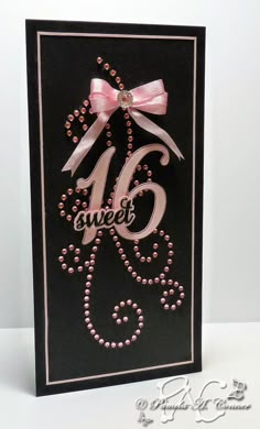 a black card with pink beads and a bow on the number six, says sweet sixteen