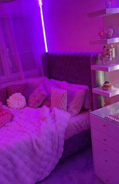 a bedroom with purple lighting and a bed in the corner that has pillows on it