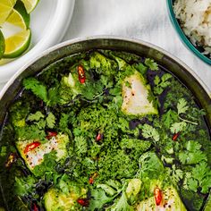 a pan filled with broccoli covered in sauce next to rice and lime wedges