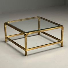 a glass and brass coffee table on a white floor