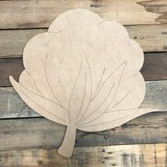 a paper cutout of a leaf on wooden planks