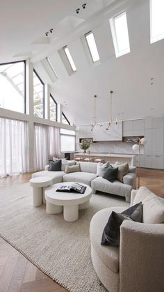 a large living room with white furniture and high ceilings