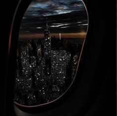 an airplane window looking out on the city at night