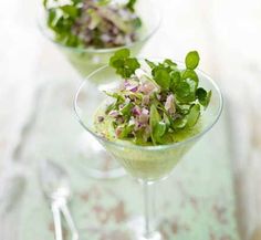 two martini glasses filled with salad and garnish