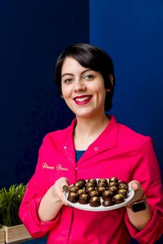 a woman holding a plate with chocolates on it