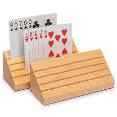 four playing cards in a wooden holder