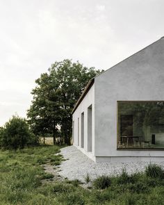 a white house sitting on top of a lush green field