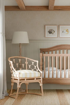 a baby's room with a crib, chair and pictures on the wall