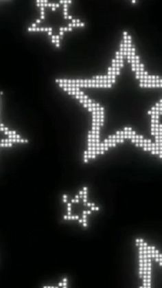 an array of pixelated white stars and numbers on a black background in the dark