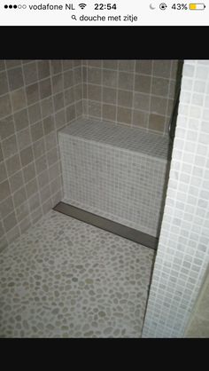 a tiled shower stall with the door open