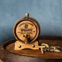 a wooden barrel sitting on top of a table next to some dry grass and a sprig