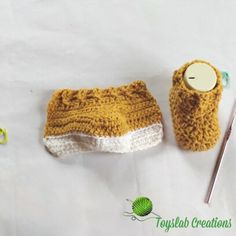 a small crocheted purse next to a sewing needle