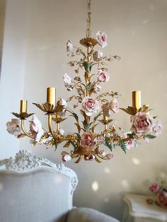 a chandelier with flowers hanging from it's ceiling in a living room