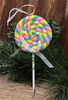 a lollipop sitting on top of a wooden table next to a pine tree