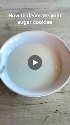 a video demonstrating how to decorate sugar cookies in a white bowl on a wooden table