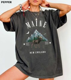 This Maine moose comfort colors shirt is super soft and cozy. Perfect to lounge around, run errands, or walk your dog. ABOUT THIS SHIRT   ∙ Shirt is UNISEX and runs slightly large for ladies (For a relaxed fit, I suggest your usual size. For an oversized fit, I suggest sizing up 1 to 2 sizes.) ∙ 100% ring spun medium-weight cotton (soft-washed and garment-dyed) ∙ Colors may vary based on your monitor/screen display or lighting CARE INSTRUCTIONS ∙ Machine wash inside out in cold water ∙ Tumble dr Christmas Graphic Tees, Christmas Graphic, Cool Ideas, Retro Stil, Jane Austen, Trending Now, Diwali, Comfort Colors, Original Design