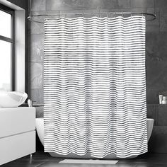 a black and white photo of a bathroom with a shower curtain that has wavy lines on it