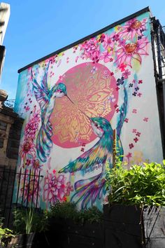 a large mural on the side of a building with birds and flowers painted on it