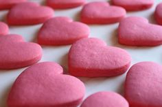 pink heart shaped cookies sitting on top of a table