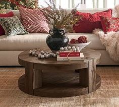 a living room decorated for christmas with red and white decorations on the couches, coffee table