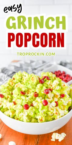 a white bowl filled with popcorn covered in green and red sprinkles on top of a wooden table