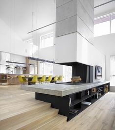 an open living room with stairs leading up to the top floor and yellow chairs on either side