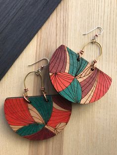 two pairs of wooden earrings sitting on top of a table