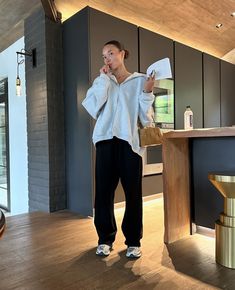 a woman standing in front of a counter holding a piece of paper