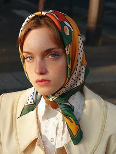 a young woman wearing a scarf around her head and looking off to the side with an intense look on her face