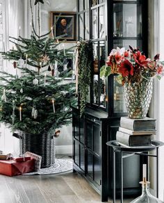 a small christmas tree in a vase next to a window