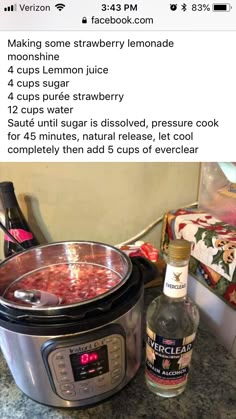 an instant pot filled with soup next to a bottle of alcohol on a counter top