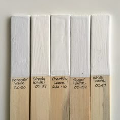 four different shades of white paint with names on them