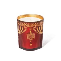 a red and gold candle holder sitting on top of a table