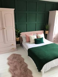 a bedroom with green walls and white flooring is pictured in this image, there is a bed that has two pillows on it