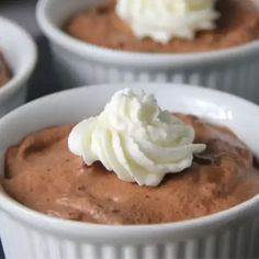 three white bowls filled with chocolate pudding and whipped cream