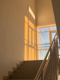 stairs leading up to an open window in a building with sunlight coming through the windows