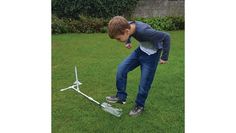 a young boy playing with a model airplane in the grass