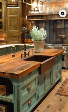 an old fashioned kitchen with green cabinets and wood floors, has a large center island in the middle