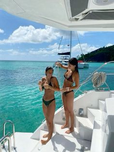 two women standing on the bow of a boat