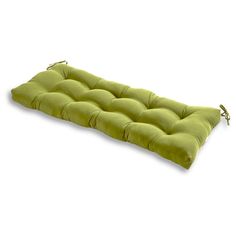 a green cushion that is sitting on the ground